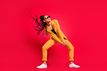 Full body photo of sweet lady dance look empty space wear eyewear yellow suit isolated on vivid red...