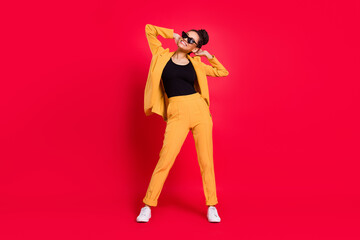 Fototapeta na wymiar Full length photo of cool lady stand wear eyewear yellow suit isolated on vivid red color background