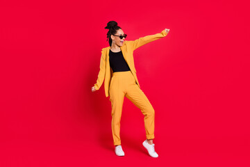 Full size photo of funny lady dance wear eyewear yellow suit isolated on vivid red color background