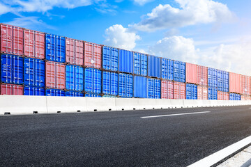 Stacked cargo containers and empty asphalt road landscape