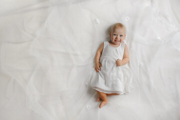 Top view on the adorable little baby lying on the bed. Concept of happy childhood.