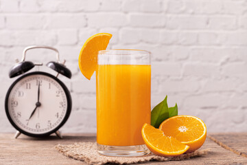 Glass of orange juice with clock.
