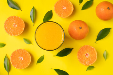 Fototapeta na wymiar Glass of orange juice on yellow background.