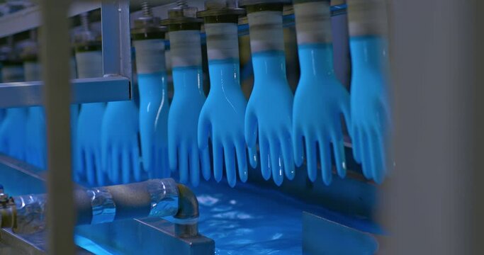 Workshop for the production of medical silicone gloves. Silicone blanks move along a conveyor belt, drying products, automated production. 4k, ProRes