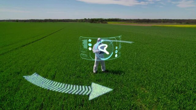 A scientist, a farmer conducts research on a farmland using augmented reality. Future-proof tools for cultivating plants, modern management of an agricultural enterprise.