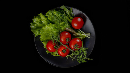 Preparation of salad on a gray plate and on a black background.