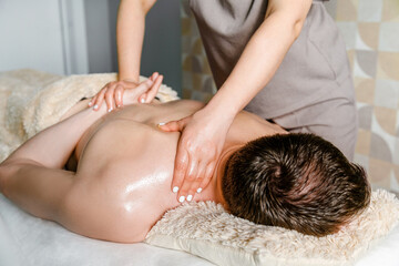 Four-handed back and shoulder massage for men in a beauty salon. Health Care Concept