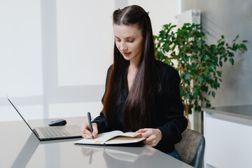 Young woman writing daily notes in agenda