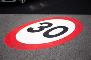 30 kilometers hour speed limit sign painted on asphalting road