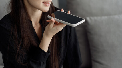 Young woman hold smartphone, recording voice message