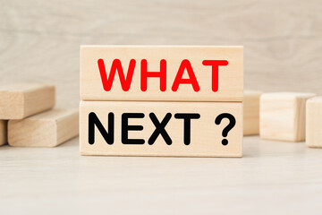 WHAT NEXT words on the wooden cubes on a bright background