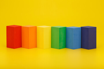 Flat lay with LGBT flag made of rectangular geometric figures on yellow background. Concept of Pride Month, human rights, LGBT community and tolerance. 