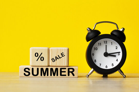 SUMMER SALE .alarm clock and wooden cubes with the text on a YELLOW background. Concept for management and business.