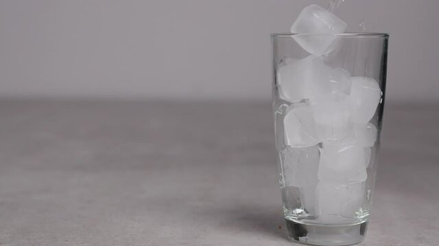 ice poured into a clear glass on a white background. Glass of soft drink.