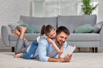 daughter congratulates her father and gives him postcard.