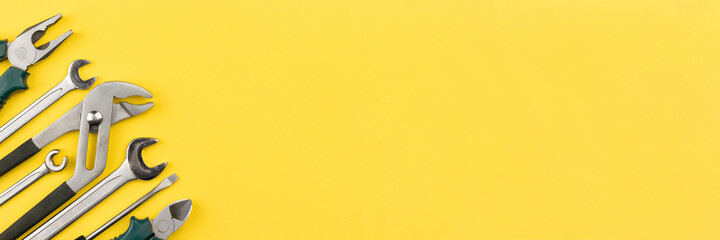 Work tools on bright yellow background, wide banner with copy space. Top view, flat lay