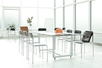 Flipchart construction helmet chairs briefcase phone handle glass table in office space