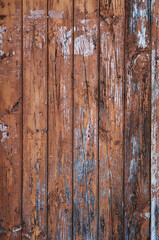 Old rustic wooden planks door with brown peeling paint, grunge background or texture