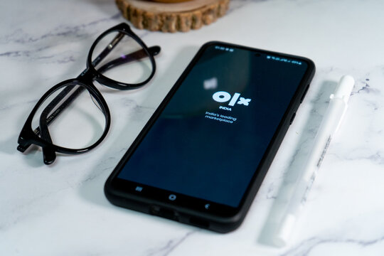flatlay shot of mobile phone showing the logo of olx india's largest second hand reseller marketplace similar to ebay and craigslist in India asia