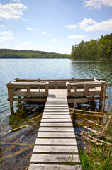 Naklejka premium Wooden fishing platform at Slowa Lake on a sunny day, Poland.
