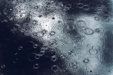 Texture with bubbles in water, autumn rain, circles and drops in puddle. Eco dark blue background