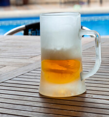 A large glass mug with cold beer
