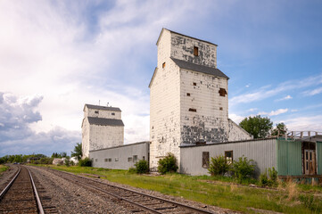 Fototapeta na wymiar De Winton, Alberta - May 5, 2021: Old grain elevators outside the small town of De Winton, Alberta.