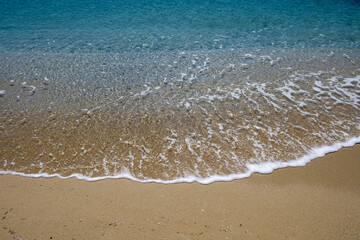 Fototapeta na wymiar Sandy beach, ocean sea water touches wet sand, summer vacations concept
