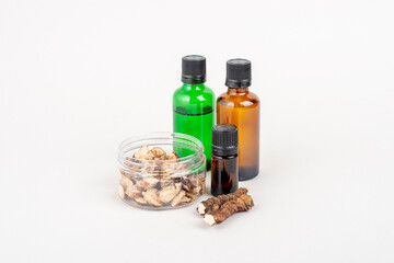 Dried Acorus calamus roots, also known as sweet flag, and bottles with oil and extract isolated on light background.