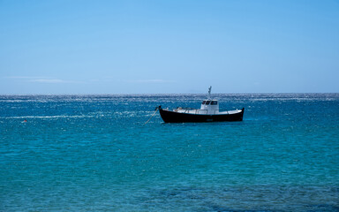Obraz premium Greece, Cyclades. Traditional boat anchored on blue color sea water