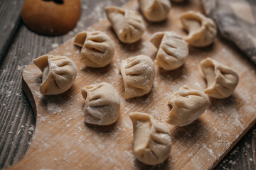 Frozen, beautifully sculpted dumplings laid out on a cutting board