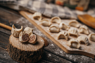 Fototapeta na wymiar Frozen, beautifully sculpted dumplings lie on the kitchen board