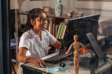 Girl doing homework online at home while quarantining of epidemic coronavirus.