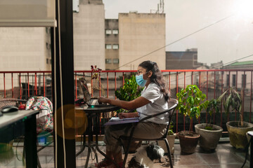 Distance learning online education. Guatemalan girl doing homework at home while quarantining of...