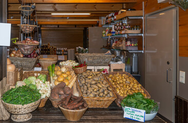 A typical stall of fresh vegetables and local food products in an indoor market in central...