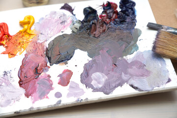 A palette with multi-colored paint and brushes for drawing. High quality photo