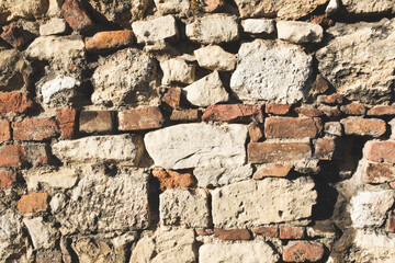 The art texture of a old stonewall and new red bricks