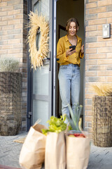 Paper bags full of fresh groceries on the porch in front of the house. Housewife receiving goods...