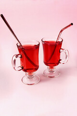 close-up of two fruit cocktails in transparent glasses on a light background, cold tropical refreshing drink, healthy natural drink