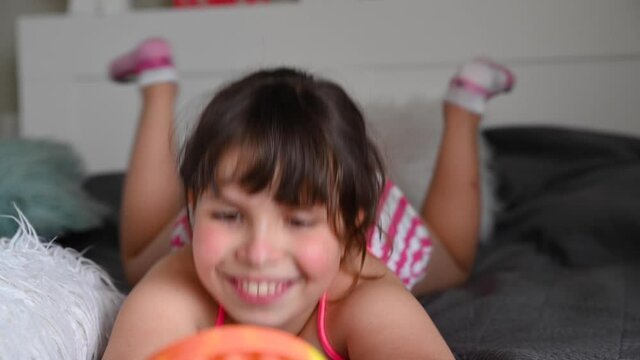 Little girl plays with pop it sensory toy simple dimple. The baby clicks on colorful rainbow soft soft silicone bubbles. Stress and anxiety relief. fidgeting game children and adults. 4k footage
