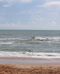 Fototapeta na wymiar The ocean waves at the beach on a sunny day.