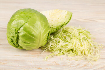 Fresh white cabbage and chopped cabbage on a wooden background. Vegetarian and diet food concept.