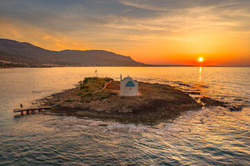 An old white church in a small island at sunset in Malia, Crete, Greece.