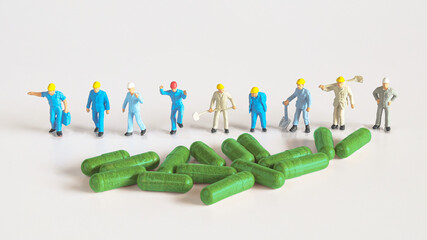 Worker figure with herb drug capsule ,health concept.