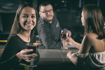 Stylish women enjoying red wine at bar counter
