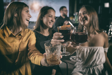 Charming women having fun, laughing and chatting at bar