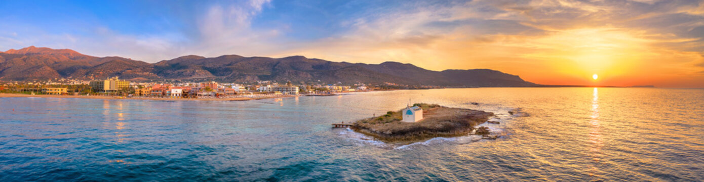 An old white church in a small island at sunset in Malia, Crete, Greece.