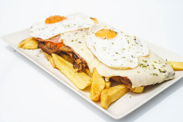 Solomillo de ternera con jamón, queso y dos huevos fritos, acompañado de patatas fritas
