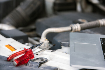 Using a laptop computer to check a car engine .