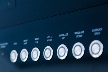 Glossy black panel with control buttons for a motor yacht.